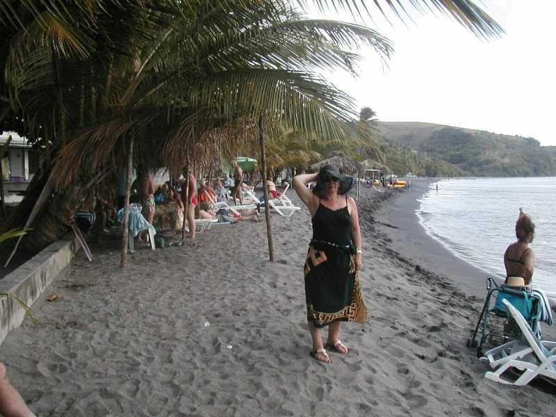 Под пальмами на бордюре вдоль всего пляжа сидят местные безработные