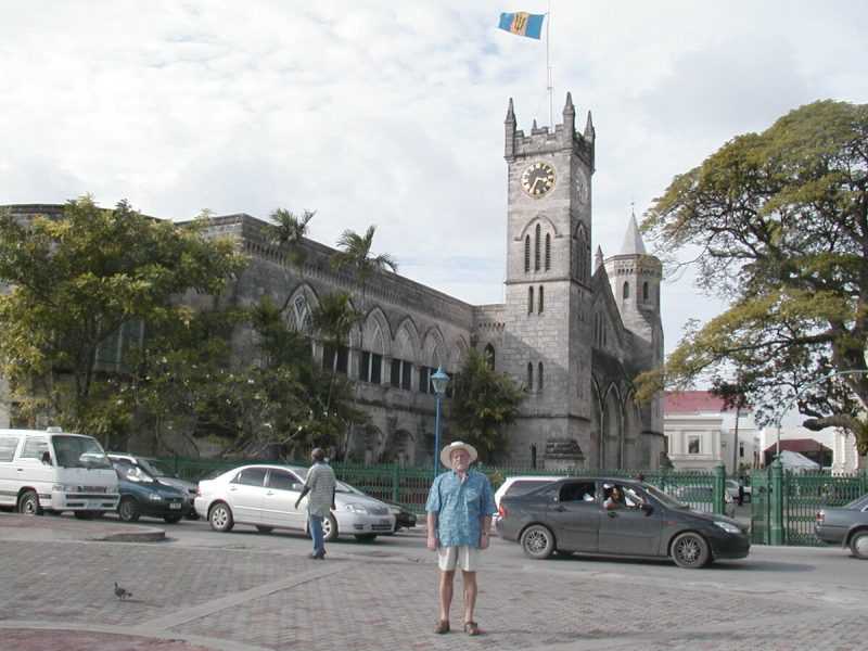 У здания Парламента с башней и миниатюрной копией Биг Бена. На башне Жовто-блакитный флаг Барбадоса с тризубом посередине.